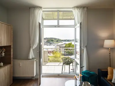 Ferienwohnung Müritzloge Waren Wohnzimmer direktem Zugang zum Balkon und Hafenblick