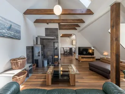 Ferienwohnung Seeperle Wohnzimmer mit Ofen und grüner Couch