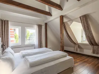 Ferienwohnung Seeperle Schlafzimmer mit großem Bett und Fenstern