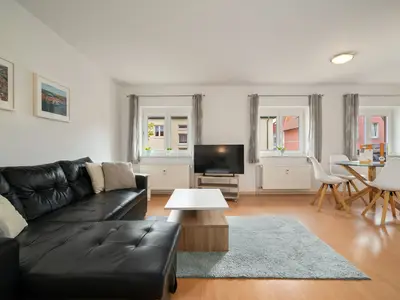 Ferienwohnung Jette Waren (Müritz) - Wohnbereich mit gemütlichen schwarzen Sofa