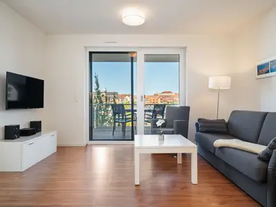 Ferienwohnung Hafenblick Waren (Müritz) – Gemütliches Wohnzimmer mit Balkonzugang und herrlichem Blick auf den Hafen