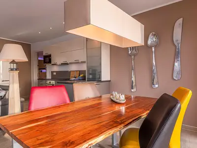 ChatGPT:  Ferienwohnung Garzini Hafenresidenz Waren (Müritz) – Stilvoller Essbereich mit Designer-Holztisch