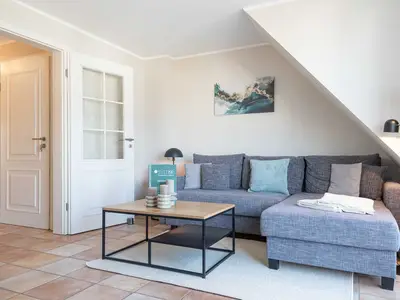 auf dem Sofa in der Ferienwohnung Carmen App. 12 liegen Kissen und eine Leselampe steht daneben