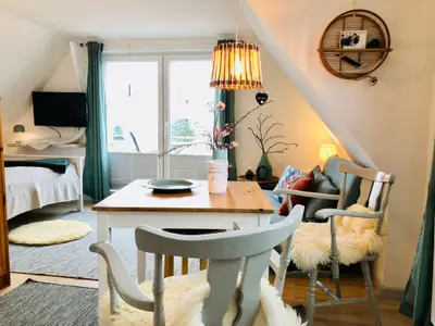 Wohnzimmer mit Schlafbereich, Sofaecke und Essplatz