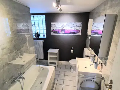 modernes Bad mit Badewanne und Duschwand