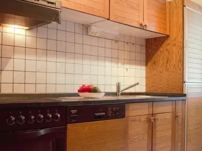 Küche mit Backofen, Cerankochfeld, Spülmaschine und Kühlschrank