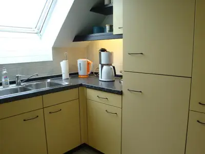 Kochbereich. Einbauküche mit Kühlschrank und Tiefkühlschrank, Kaffeemaschine, Wasserkocher,