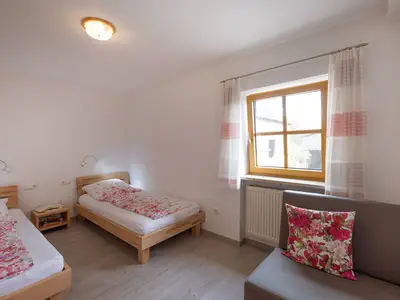 Schalfzimmer mit getrennten Betten und kleinem Sofa
