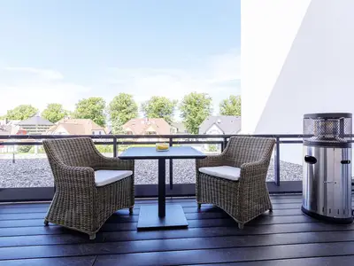 Ferienwohnung First Garden View Wustrow – Großer Balkon mit gemütlicher Sitzlounge und schönem Blick über die Dächer