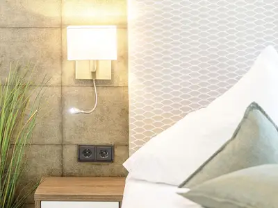 Ferienwohnung First Garden View Wustrow – detailverliebtes Schlafzimmer mit stilvoller Wandlampen