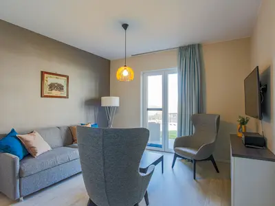 ChatGPT:  Ferienapartment Ostseestuv Wustrow – Stilvoller Wohnbereich mit gemütlicher Sitzecke und Zugang zur Terrasse