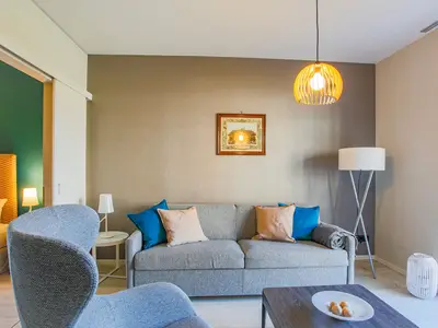 ChatGPT:  Ferienapartment Ostseestuv Wustrow – Eleganter Wohnbereich mit gemütlichem Sofa und stilvollem Ambiente