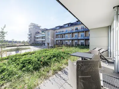 Ferienapartment Ostseestuv Wustrow – Sonnige Terrasse mit gemütlicher Sitzlounge und Blick ins Grüne