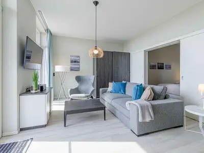 Ferienwohnung Windröschen in Wustrow – stilvolles, modern eingerichtetes Wohnzimmer mit gemütlichem Sofa