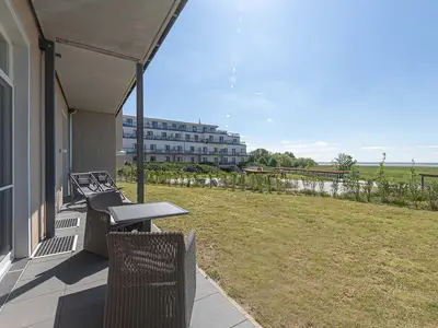 Ferienwohnung Windröschen in Wustrow – sonnige Terrasse mit Gartenblick, gemütlicher Sitzgruppe und Zugang ins Grüne