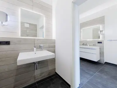 Ferienwohnung Windröschen in Wustrow – modernes, helles Badezimmer mit stilvollem Waschtisch, großem Spiegel