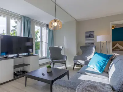 Ferienwohnung Lüttkoje Ostseebad Wustrow – heller Wohnbereich mit gemütlicher Sitzecke, moderner Ausstattung