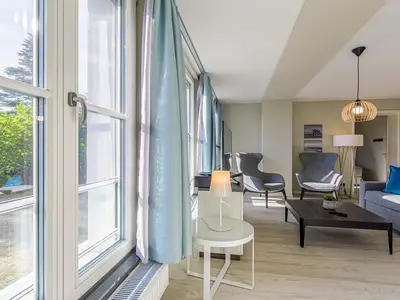 Ferienwohnung Lüttkoje Ostseebad Wustrow – heller Wohnbereich mit großen Fensterfronten, viel Tageslicht