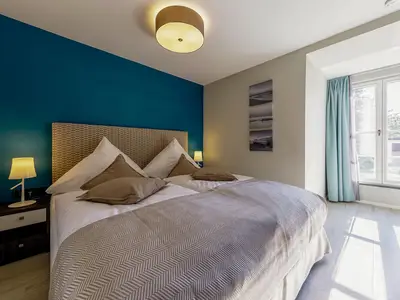 Ferienwohnung Lüttkoje Ostseebad Wustrow – ruhiges Schlafzimmer mit komfortablem Doppelbett, maritimer Farbgestaltung