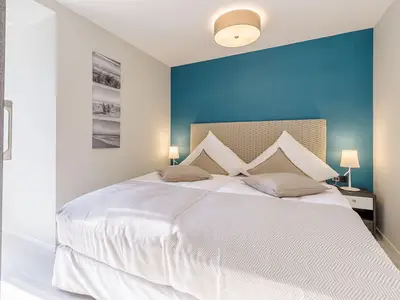 Ferienwohnung Lüttkoje Ostseebad Wustrow – komfortables Schlafzimmer mit großzügigem Doppelbett, ruhiger Farbgestaltung