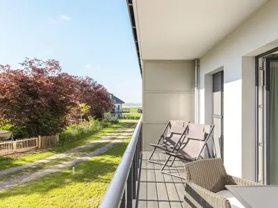 Ferienwohnung Lüttstuv Ostseebad Wustrow – sonniger Balkon mit gemütlichen Sitzmöbeln und Blick ins Grüne