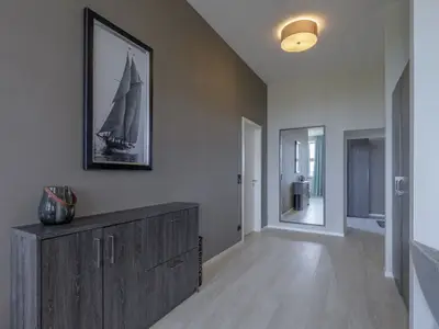 Ferienwohnung Panorama-Utkiek in Wustrow – Moderner Eingangsbereich mit Flur, Stauraum und maritimen Akzenten
