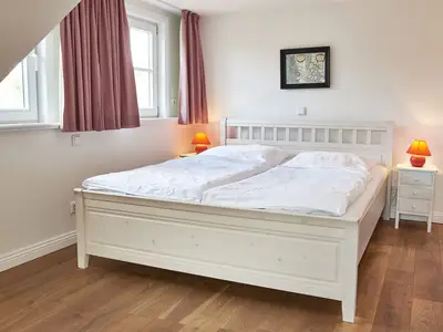 Das erste Schlafzimmer verfügt über ein Doppelbett und eine Sitzecke.