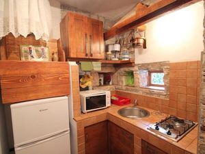 Die Küche mit Herd, Mikrowelle und Kühlschrank