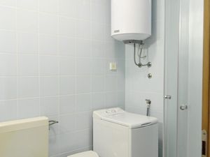 Das Badezimmer verfügt über eine Waschmaschine, Dusche und WC.