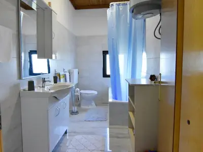 Das Badezimmer hat eine Badewanne, Waschbecken mit Schrank und Spiegel, WC.