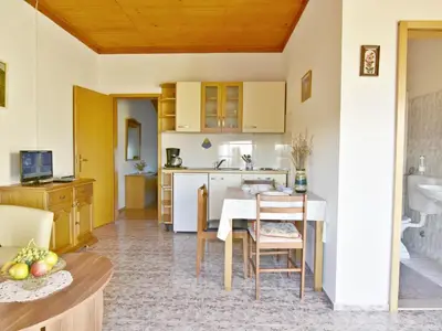 Die Küche ist ausgestattet mit Herd, Kühlschrank, Kaffeemaschine, Esstisch und Stühlen