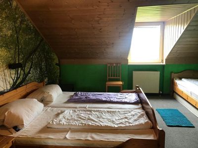 Schlafzimmer mit drei Betten (Doppelbett und Einzelbett in der Nische) mit direktem Zugang zum Badezimmer