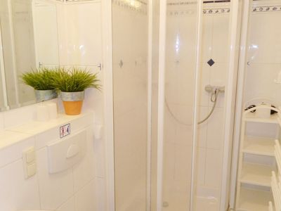 Badezimmer mit Spiegel, Waschbecken, WC und Dusche