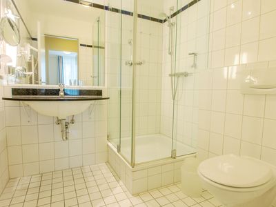 Badezimmer mit Dusche, WC, Waschbecken und Spiegel