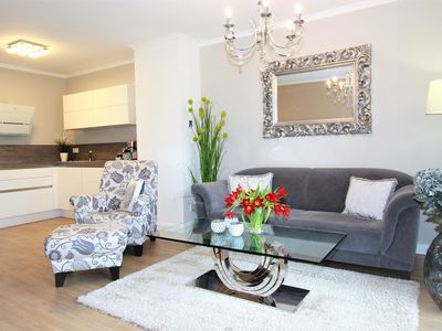 offener Wohnbereich mit Küche, Sofa, Couchtisch und Sessel