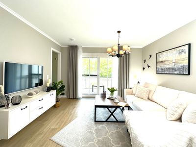 offener Wohnbereich mit Sofa, Couchtisch, Sideboard und TV