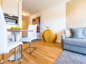 offene Küche mit Esstisch, Bestuhlung und Wohnbereich mit Sofa