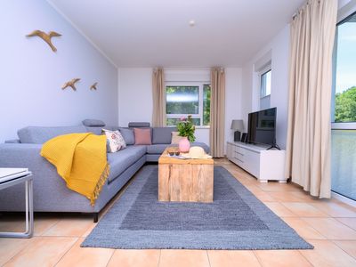 Wohnzimmer mit Sofa, Sideboard und TV