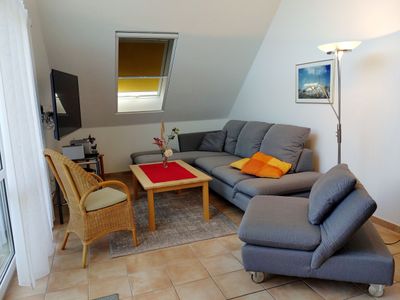 Wohnzimmer mit Sofa, Sessel, Couchtisch und TV