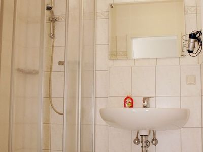 Badezimmer mit Dusche, WC, Spiegel und Waschbecken