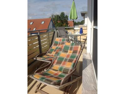 Balkon mit Sonnenliegen und Tisch mit Bestuhlung