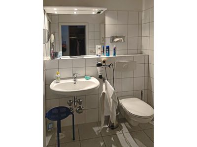 Badezimmer mit Dusche, WC, Spiegel und Waschbecken