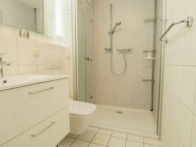 Badezimmer mit Dusche, WC, Waschbecken und Spiegel