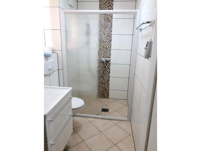 Badezimmer mit WC, Dusche, Waschbecken und Spiegel
