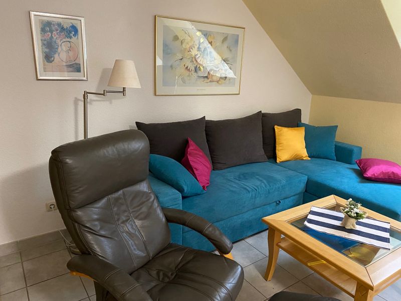 Wohnbereich mit Sofa, Sessel und Couchtisch