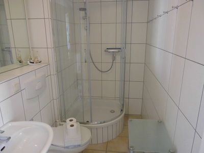 Badezimmer mit Dusche, WC, Spiegel und Waschbecken