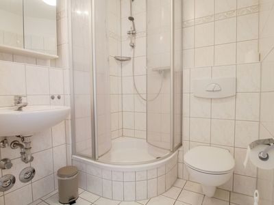 Badezimmer mit WC, Dusche, Waschbecken und Spiegel