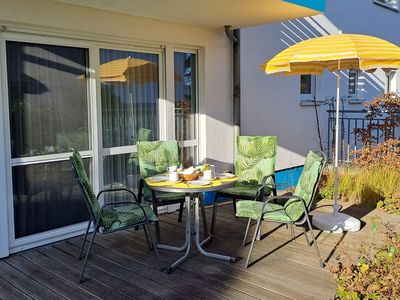Terrasse mit Tisch, Bestuhlung und Sonnenschirm