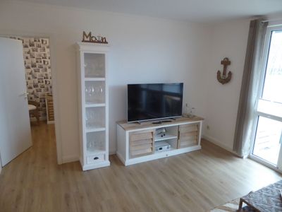 Sideboard mit TV und einem mit Gläsern gefüllten Regal