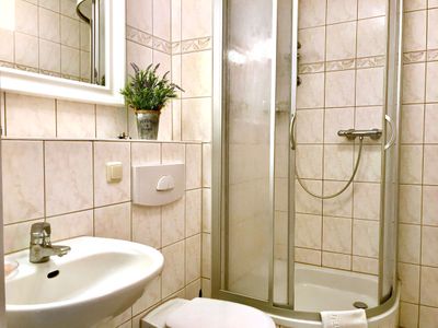 Badezimmer mit Spiegel, Waschbecken, WC und Dusche